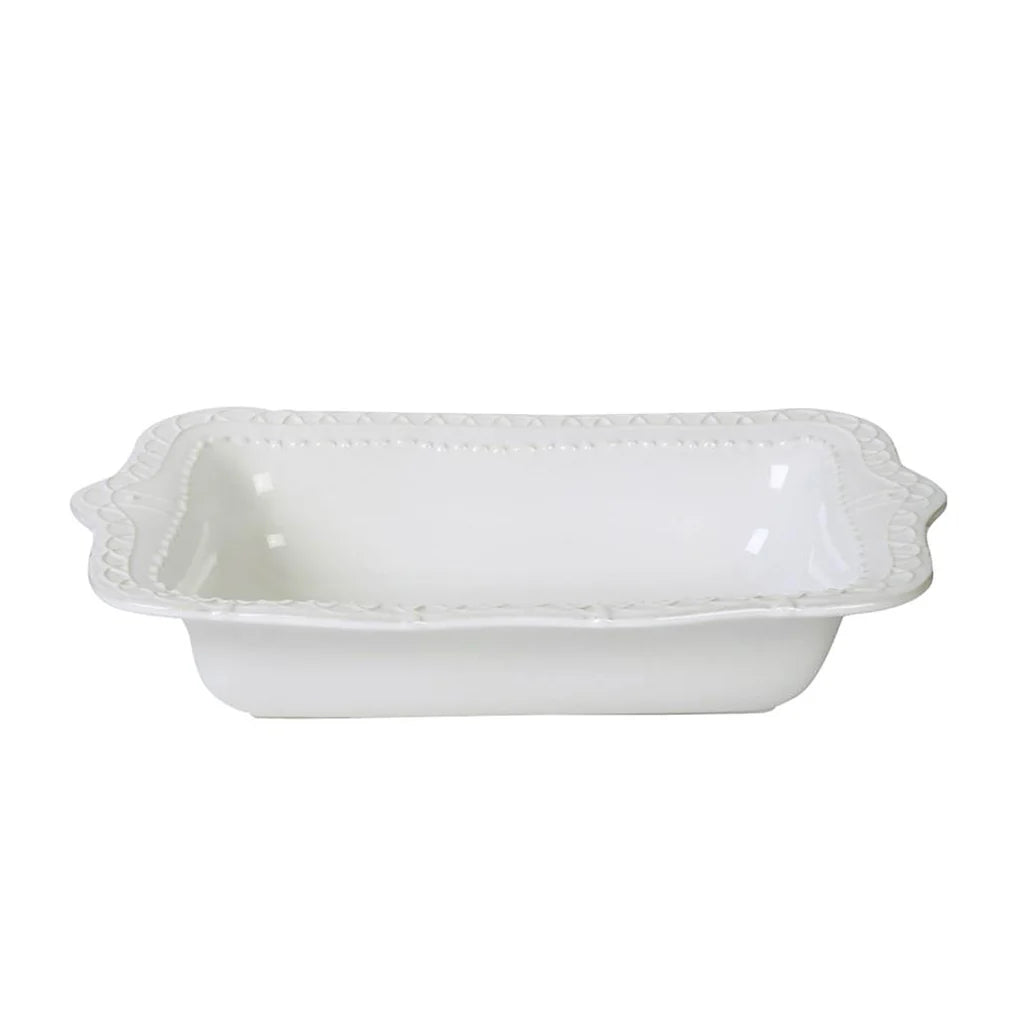White ceramic baking dish with decorative edges on a white background