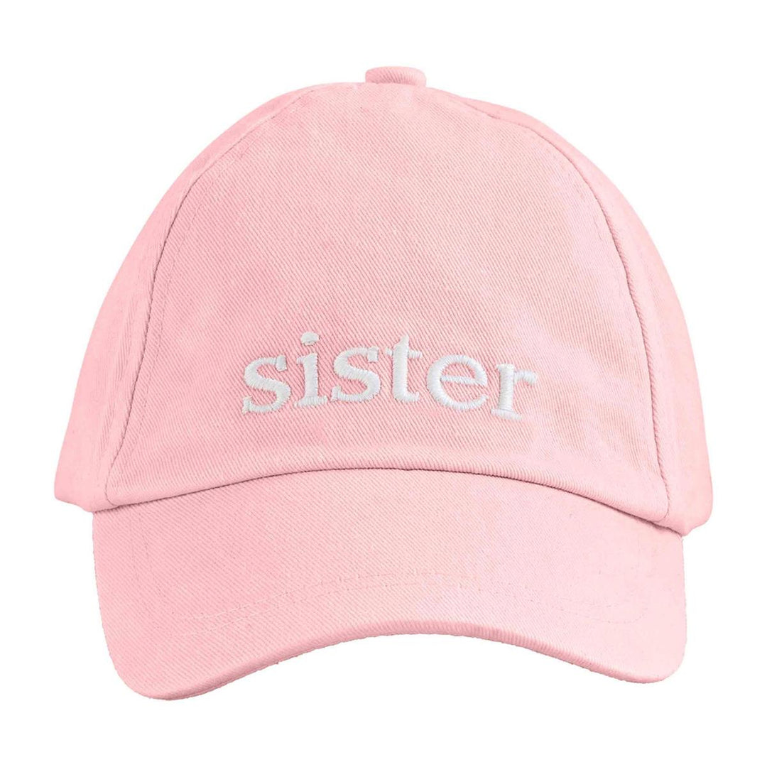 Pink cap with 'sister' embroidered on it against a white background