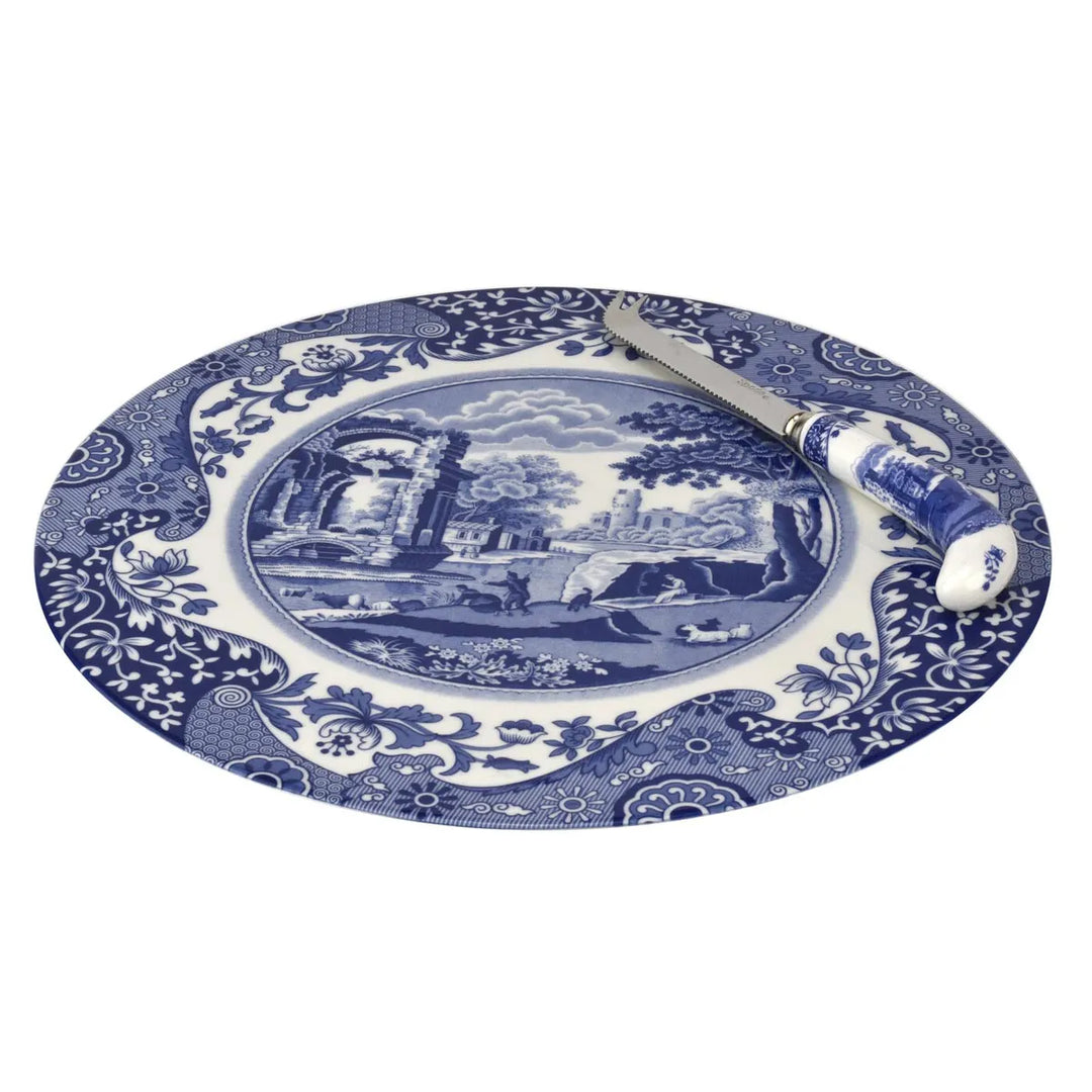 Blue and white decorative plate with a scenic design and a knife on a white background