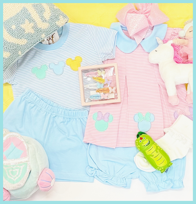 Children's clothing and accessories including a striped shirt, shorts, and toys on a yellow background.