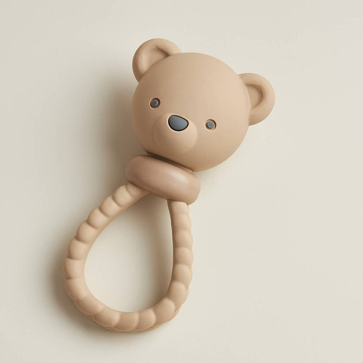 Beige teddy bear-shaped teething ring on a light beige background