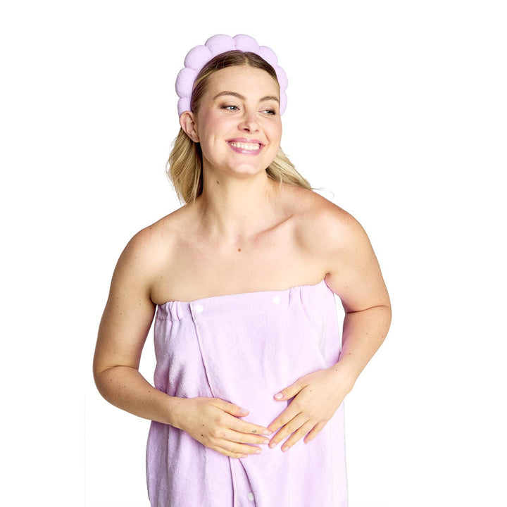 Woman wearing a purple headband and towel on a white background