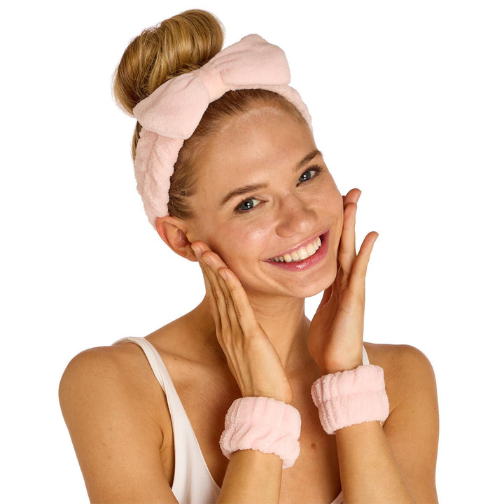 Woman wearing pink headband and wristbands on a white background