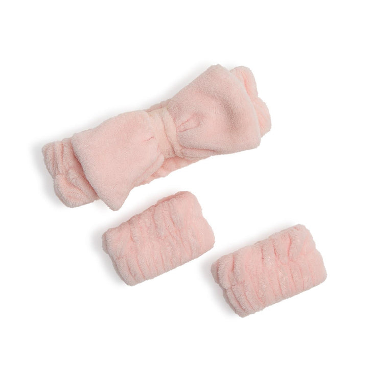 Set of pink knitted items on a white background