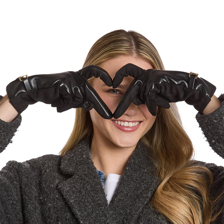 Woman wearing black gloves forming a heart shape with her fingers on a white background