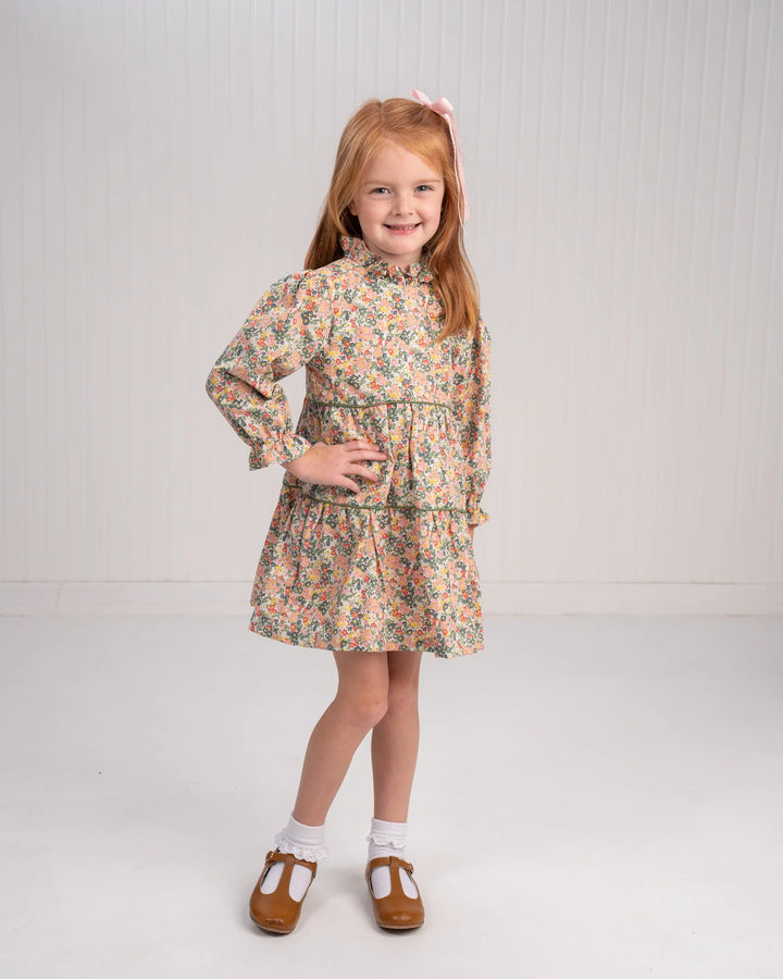 Young girl wearing a floral dress on a plain background