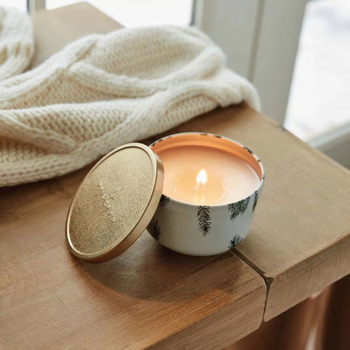 Frasier Fir travel tin candle in a styled holiday arrangement