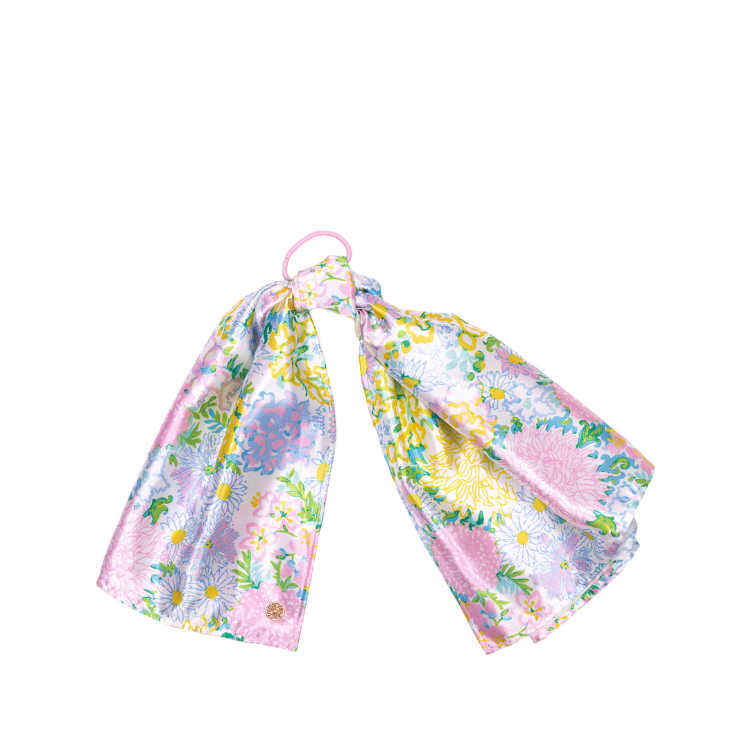 Floral headband with a pink hair tie on a white background