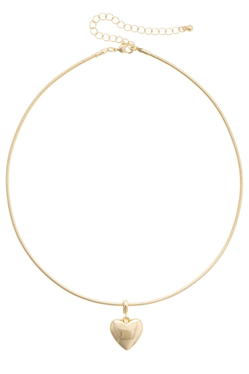 Gold necklace with a heart pendant on a white background
