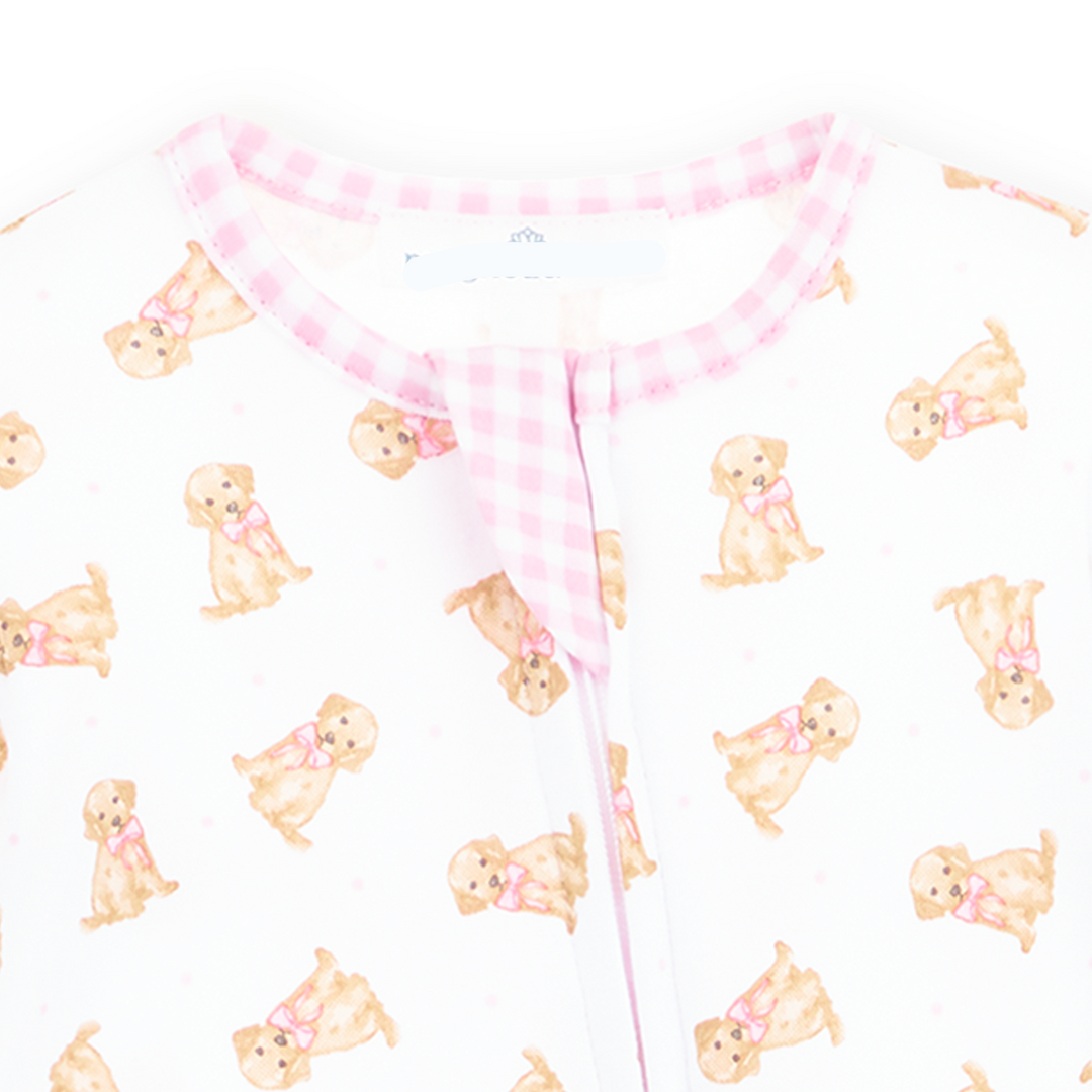 Allover golden puppy print on a white background footie with light pink gingham trim and long sleeves