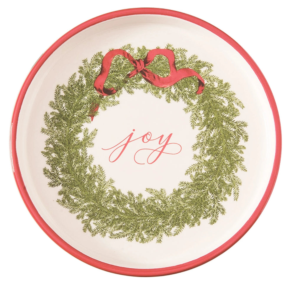 Decorative plate with a green wreath, red ribbon, and 'joy' text on a white background