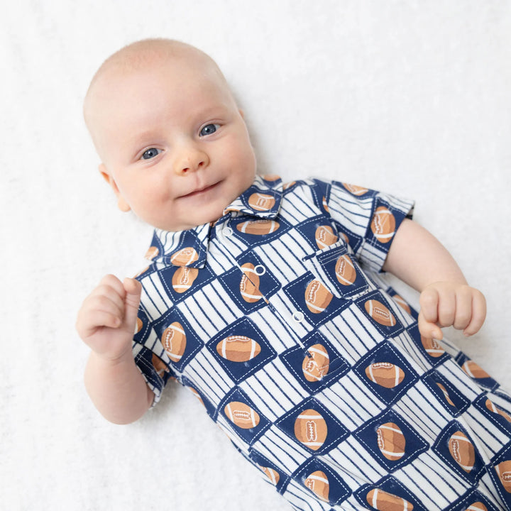 Angel Dear Football Patchwork Polo Shortie worn by a baby in a lifestyle view highlighting the football patchwork design in an additional catalog photo