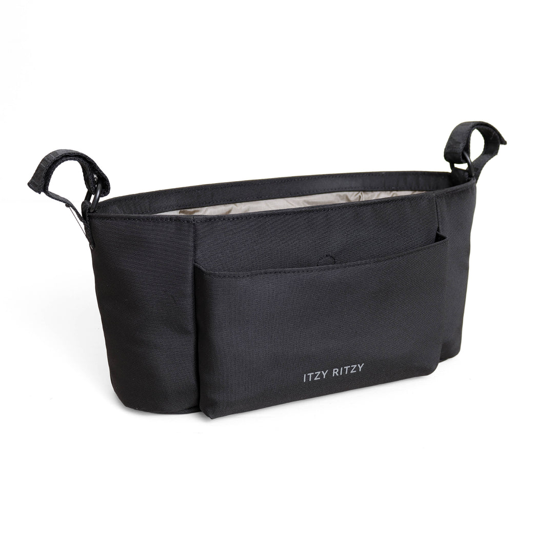 A black diaper bag with a front pocket and side handles, featuring the brand name 'ITZY RITZY' printed in white on the lower front, set against a plain white background.