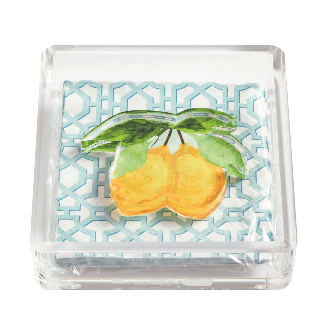Clear acrylic napkin holder with blue geometric print paper napkins and watercolor lemon paperweight