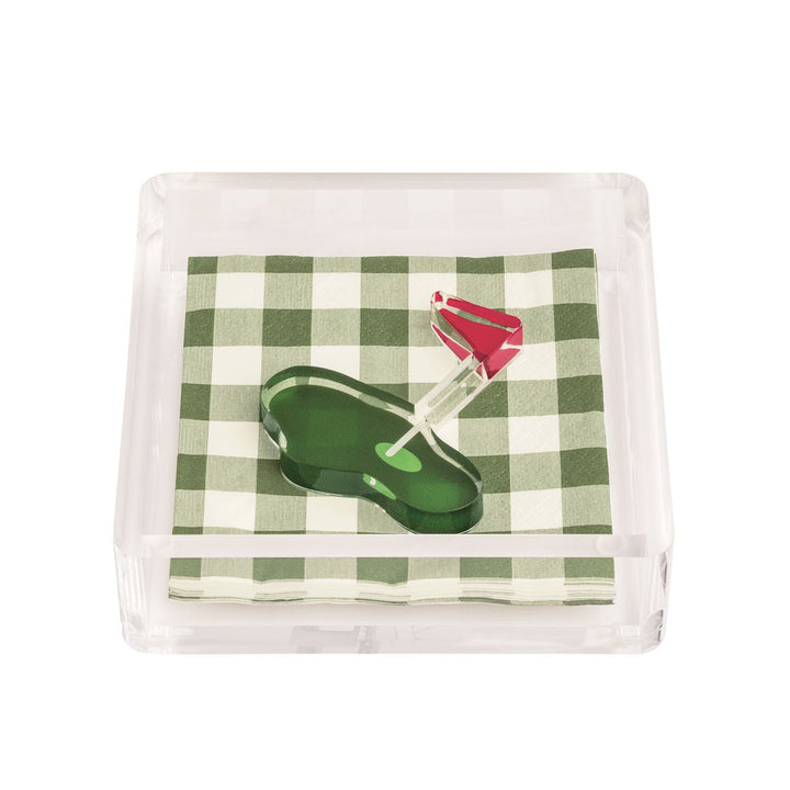Clear acrylic napkin holder with green gingham paper napkins and golf-themed cocktail picks featuring green putting surface and red flag