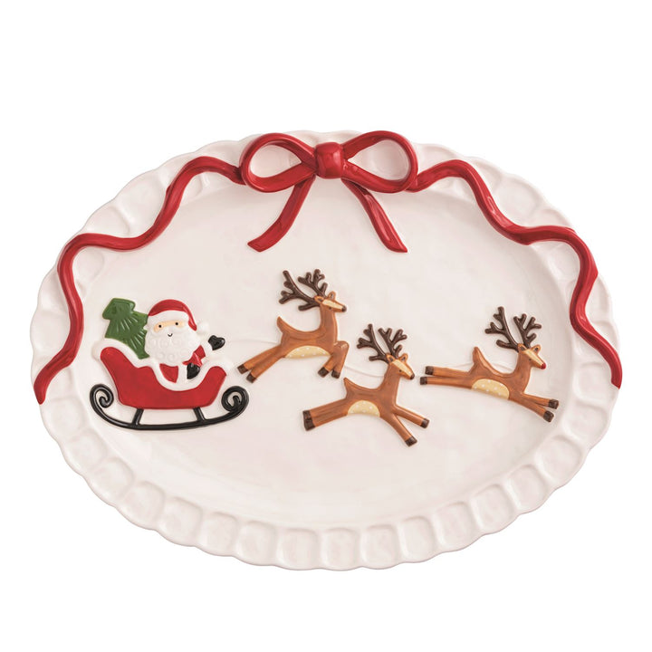 Hand-painted stoneware coupe shaped platter with raised in-mold Santa's sleigh and attached bow.