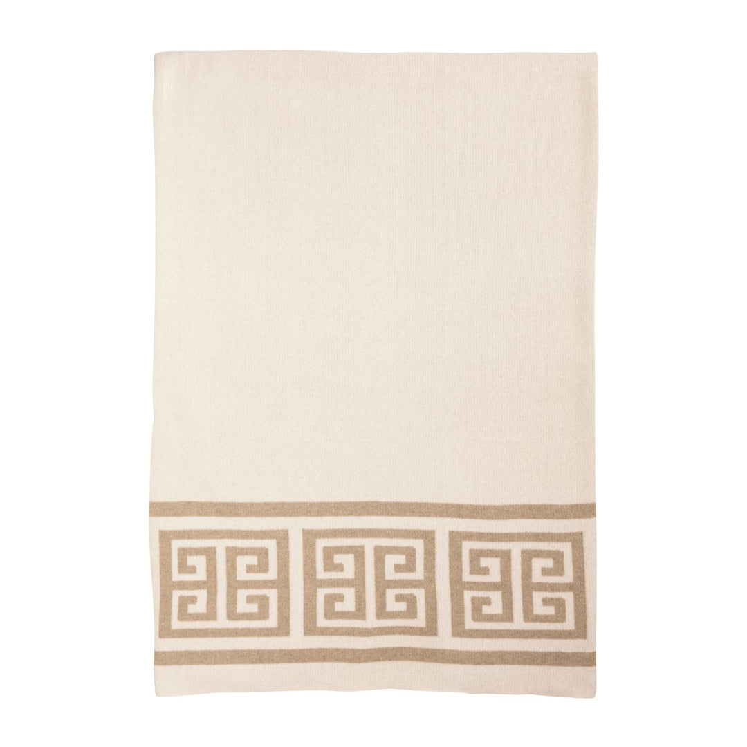 Neutral cream throw blanket with classic Greek key trim border, styled over a sofa for elegant home décor.