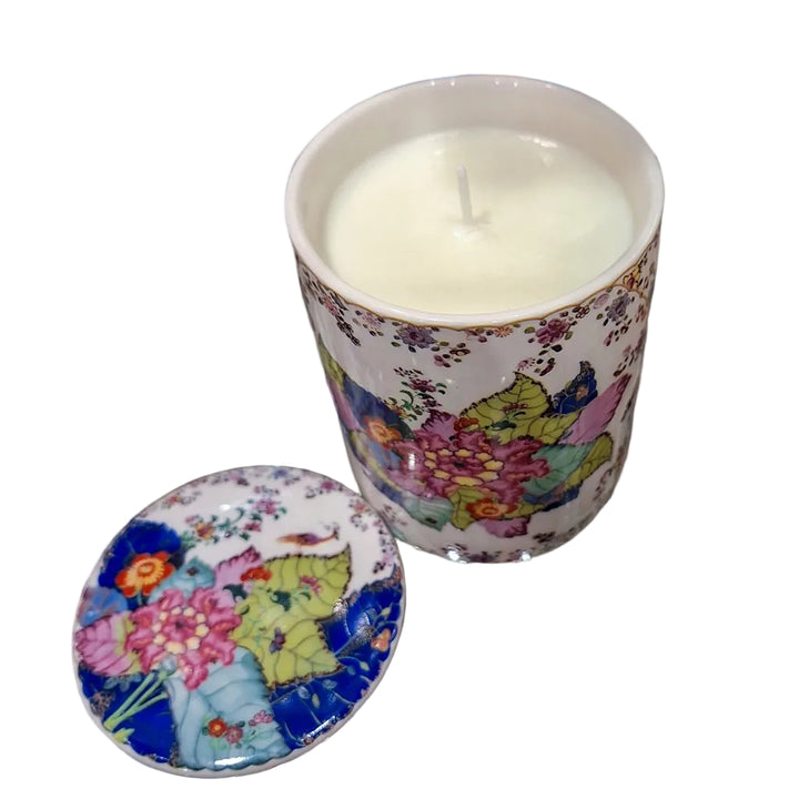 Decorative candle in a colorful holder on a reflective surface
