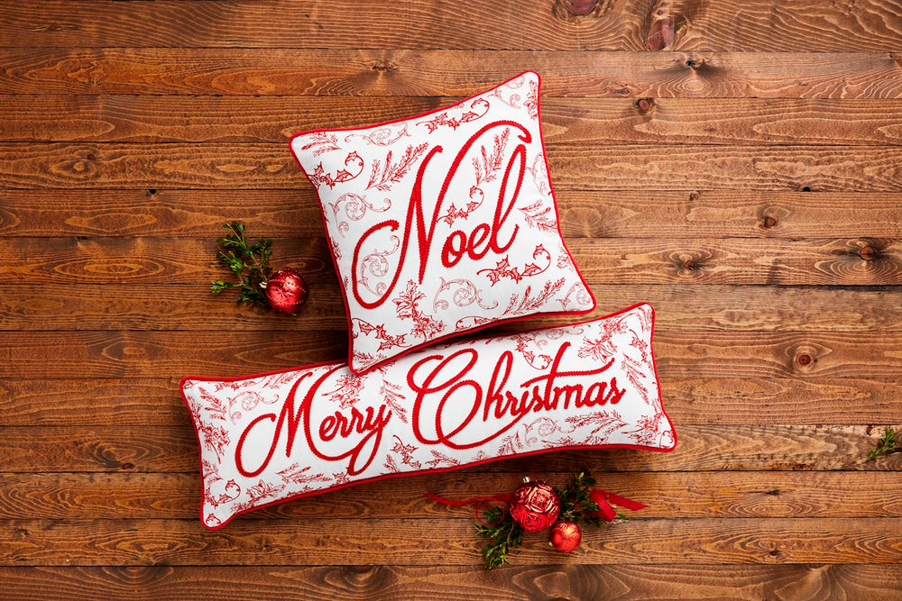 Embroidered red pillows on wood background
