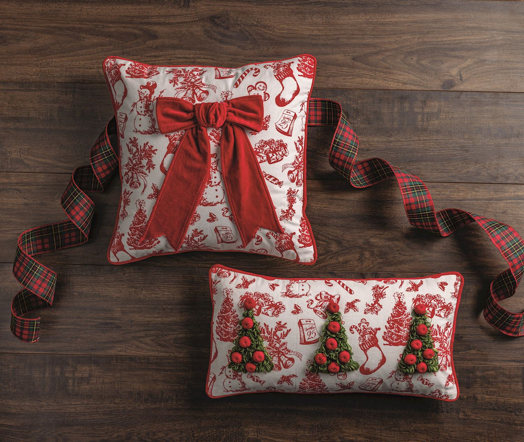Toile cotton pillow features dimensional looped yarn trees, piped edge and tartan backing. Zipper closure on wood background with ribbon