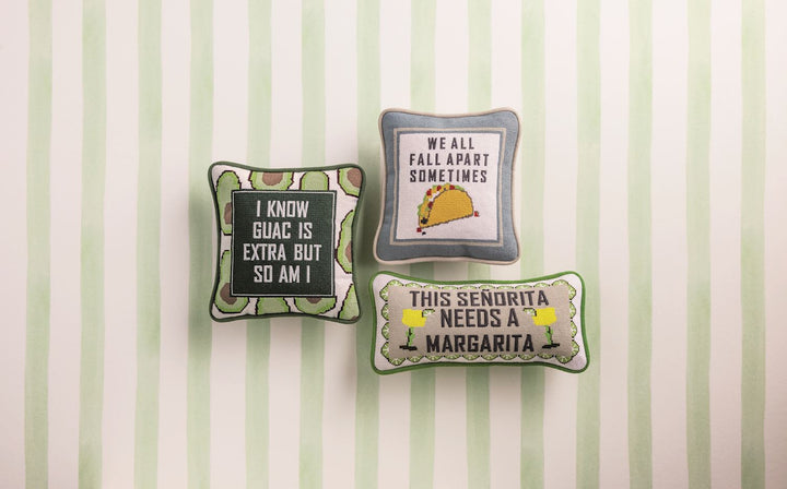 MEXICAN FOOD INSPIRED NEEDLEPOINT PILLOWS ON GREEN AND WHITE STRIPED BACKGROUND