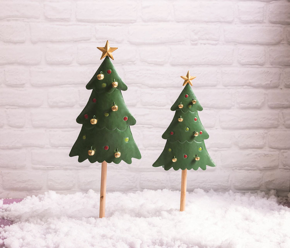 Two Christmas tree-shaped toppers with decorative elements on a white background in snow