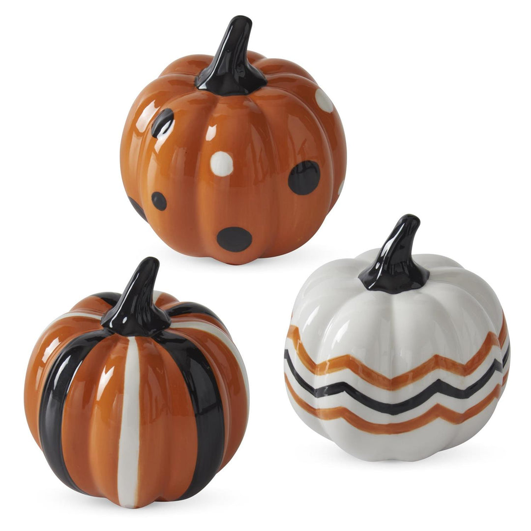 Three ceramic pumpkins with different patterns on a white background