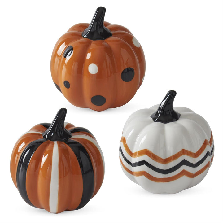 Three ceramic pumpkins with different patterns on a white background