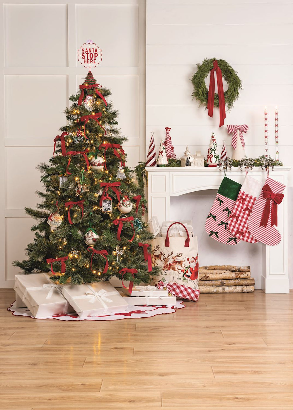Decorated Christmas tree with stockings and presents in a living room.