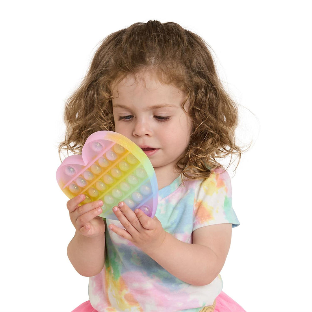 Child holding a colorful heart-shaped pop-it toy on a white background