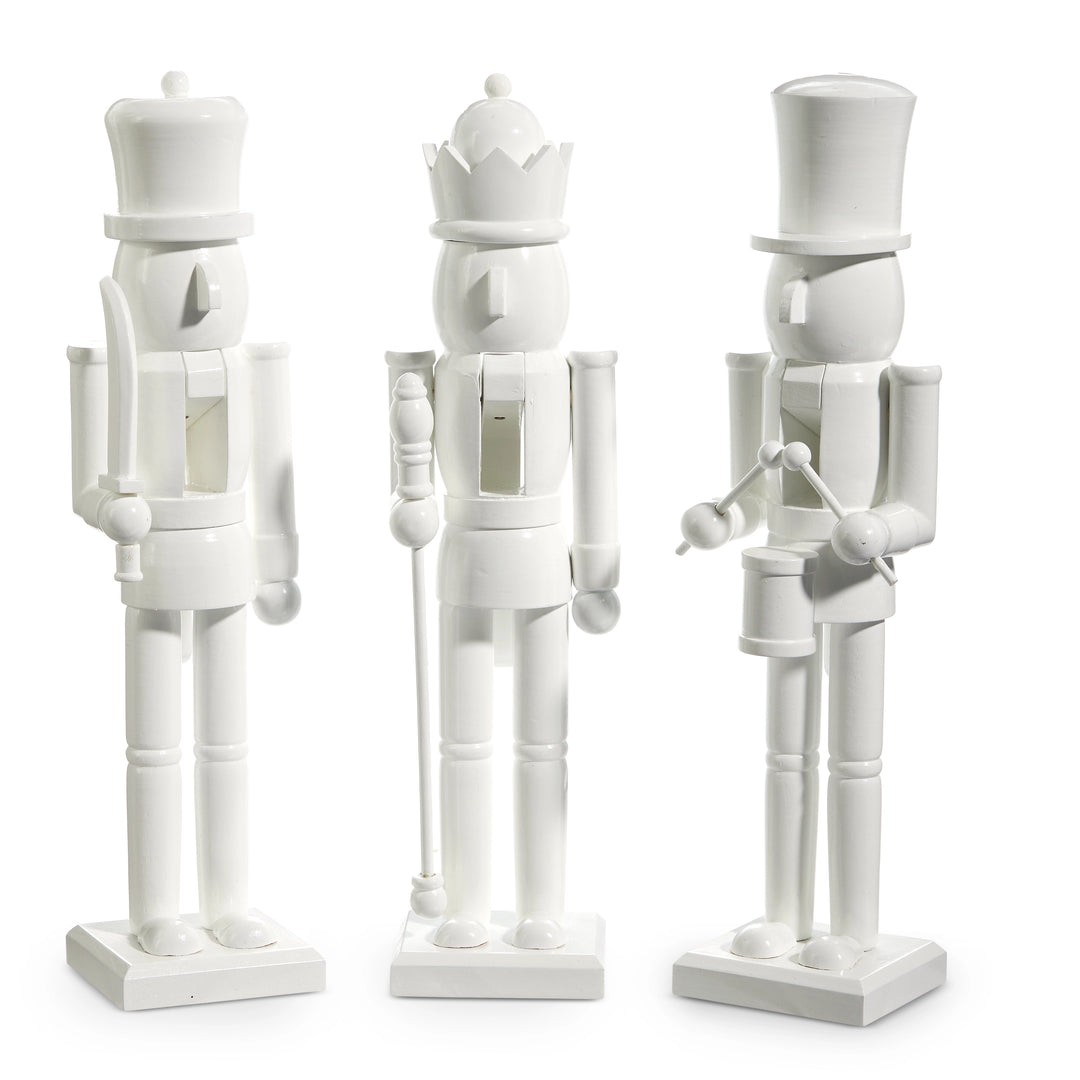 Three white wooden nutcrackers with different poses on a white background