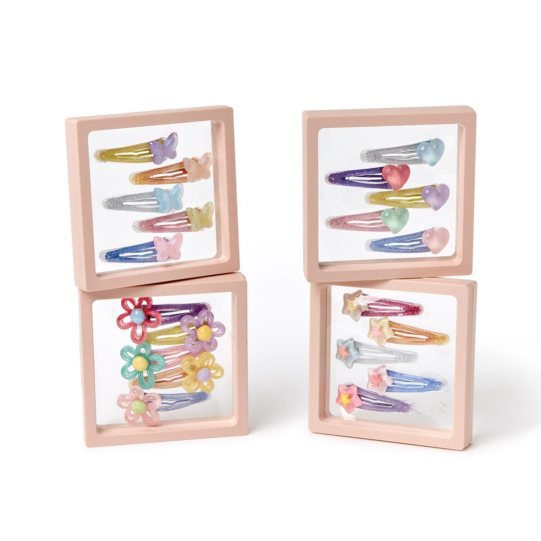 Set of colorful hair clips in wooden display cases on a white background