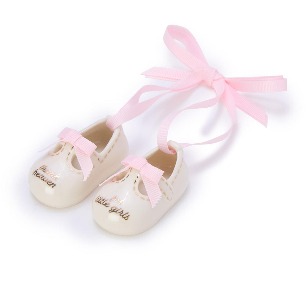 White baby shoes with pink bows on a white background