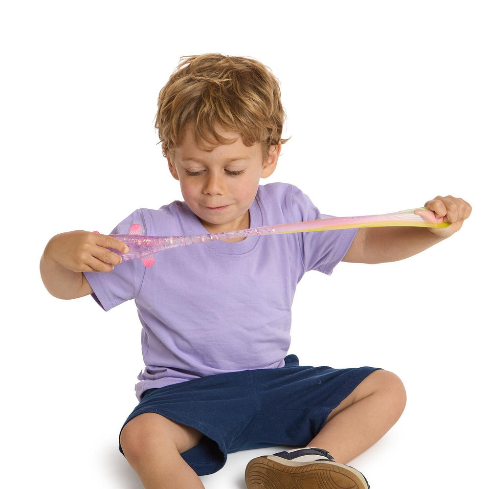 Child playing with a long, thin object on a white background
