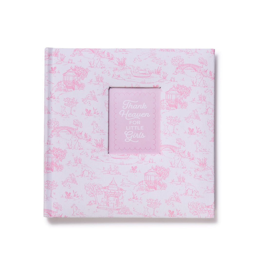 Pink and white baby book with floral pattern and 'Thank Heaven for Little Girls' text on a white background