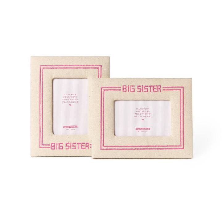 Two beige picture frames with pink accents and 'BIG SISTER' text on a white background.