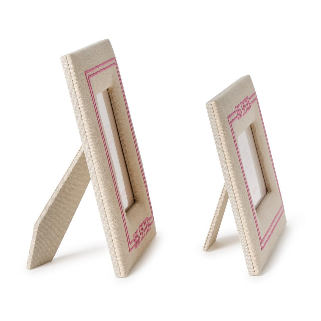 Two beige picture frames with pink accents on a white background