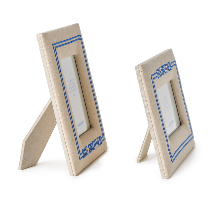 Two beige picture frames with blue accents on a white background