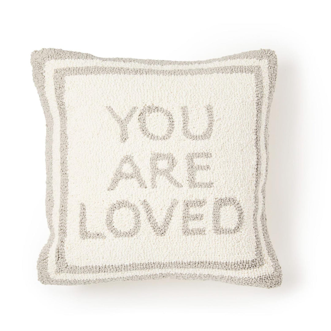 Decorative pillow with 'YOU ARE LOVED' text on a white background