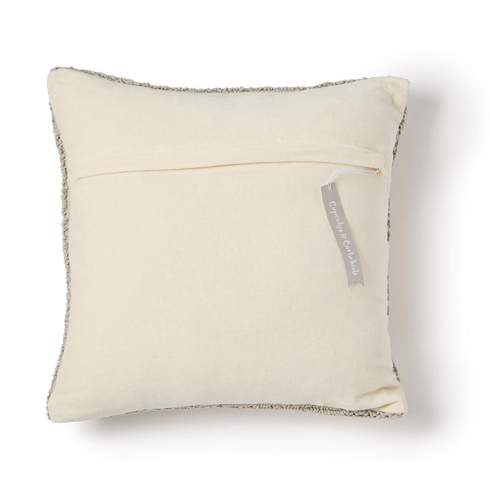 Beige pillow with textured edge and visible brand tag on a white background