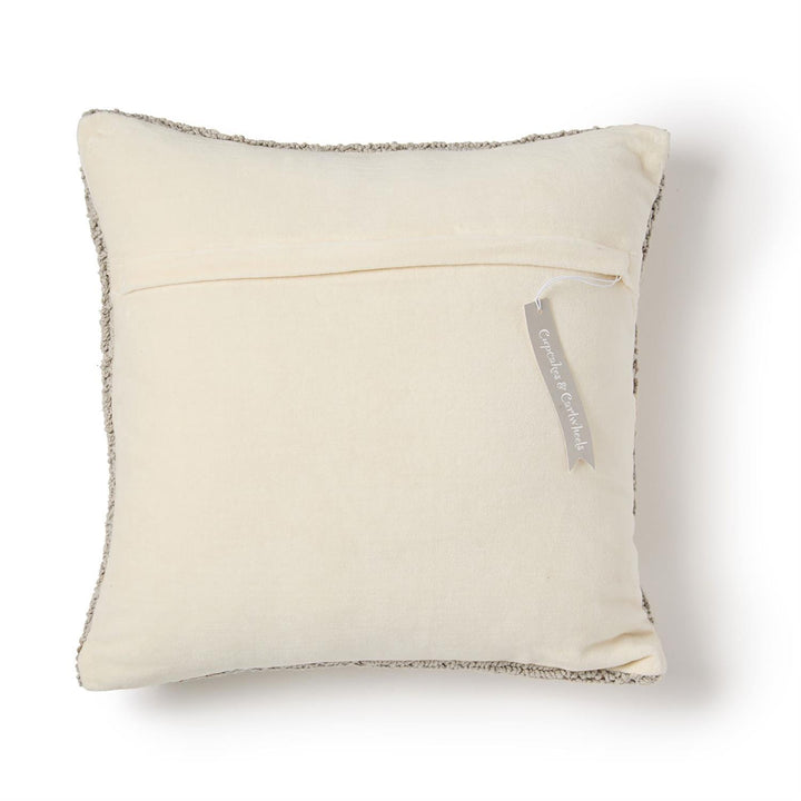 Beige pillow with textured edge and visible brand tag on a white background
