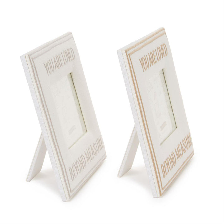 Two white photo frames with gold text on a white background