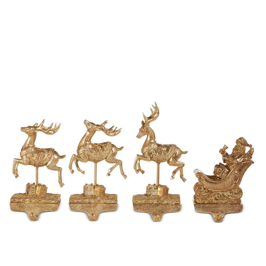Set of gold deer and sleigh figurines on a white background