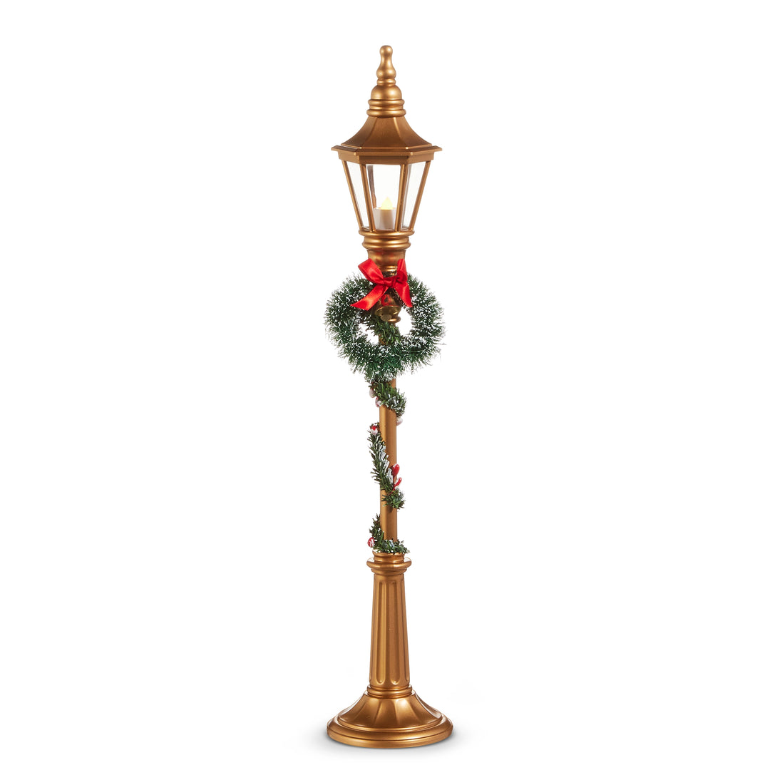Decorative Christmas lamp post with wreath and bow on a white background