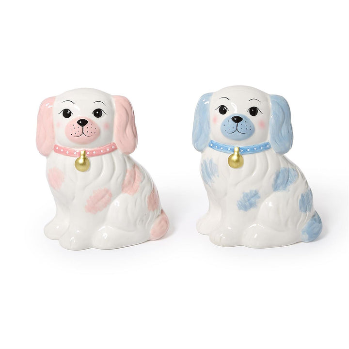 Two ceramic dog figurines, one pink and one blue, on a white background