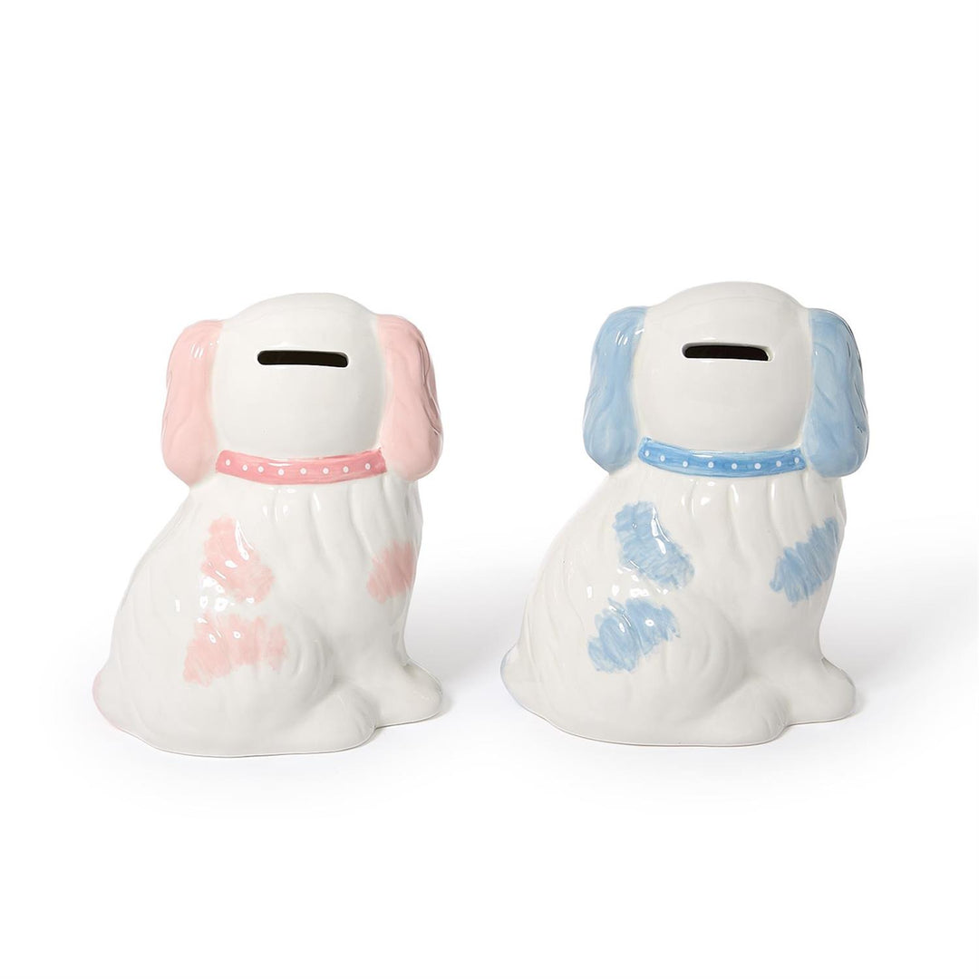Two ceramic dog-shaped piggy banks, one with pink accents and the other with blue, on a white background.