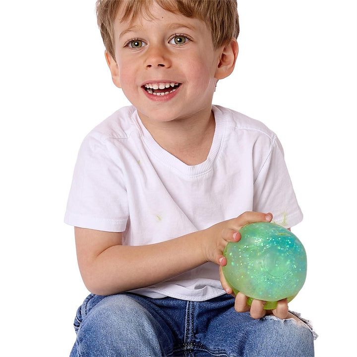 Child holding a green and blue ball against a white background