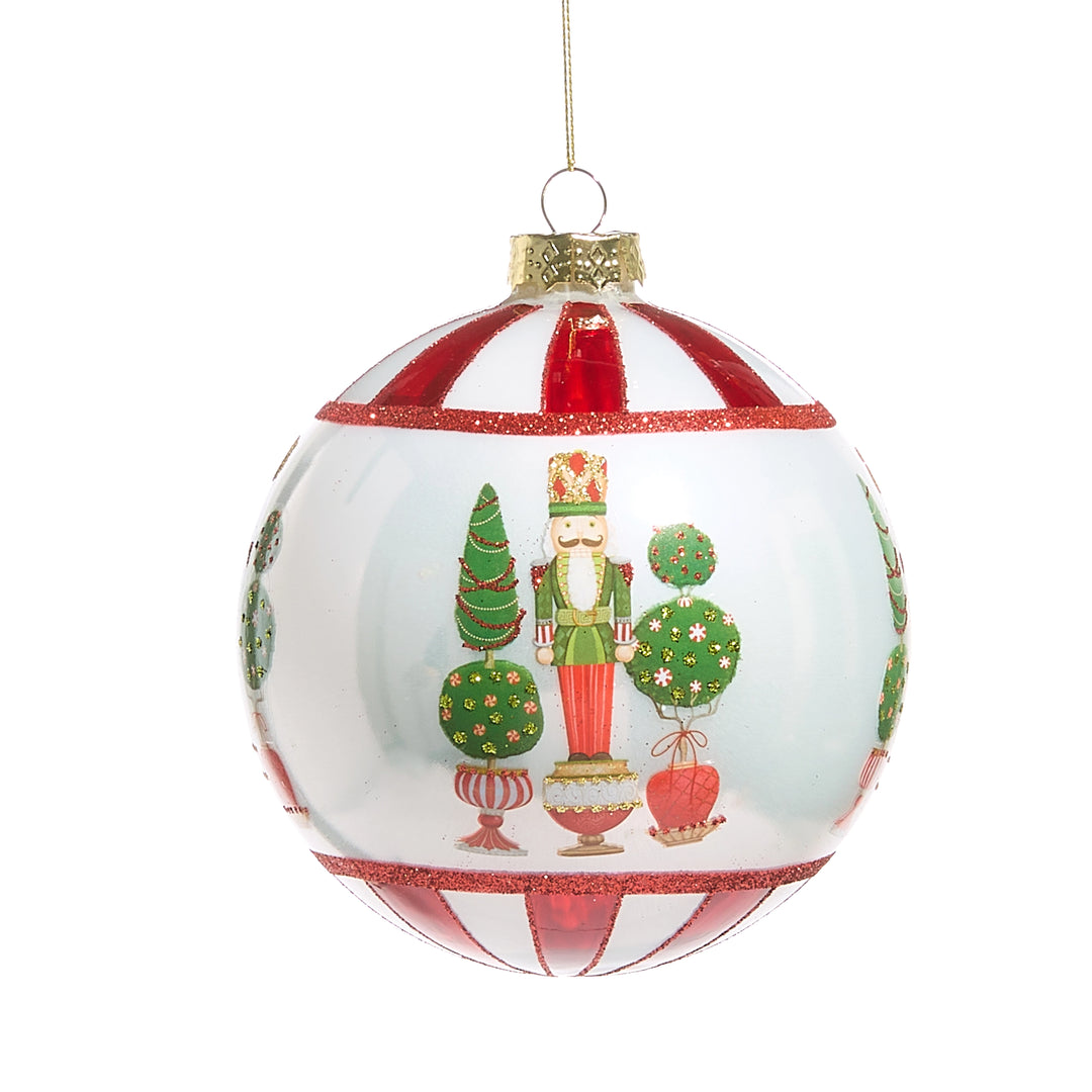 FESTIVE GLASS BALL ORNAMENT WITH NUTCRACKER AND TOPIARY ACCENTS