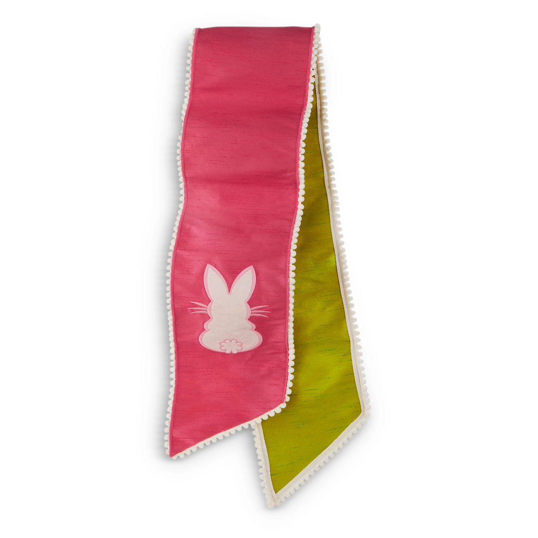 Two-toned pink and green ribbon with a white bunny silhouette on a white background