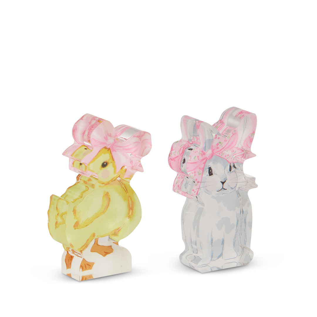 Two decorative figurines of a yellow chick and a gray rabbit wearing pink hats on a white background.